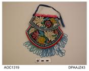 Bag, brown velvet, heavily embroidered all over with multi coloured stylized floral design, decorative flaps attached to front and back, edges bound red wool, pale blue bead fringe to lower edges, top opening bound pink ribbon, blue ribbon handle strap,