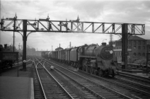 Digital image copy at 800 dpi of an original black and white print photograph retained by donor of Mike Peart, showing a locomotive 75078 with train travelling through Eastleigh.