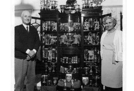 Arthur Pearce and his wife Lillian next to Pearces collection of trophies