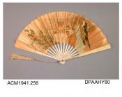 Fan, yellow satin leaf printed scene in restaurant, plus holly and misteltoe on left of leaf, entitled First Arrival, made in Paris, plain white wooden sticks and guards, metal loop, cream silk cord and tassel, approximate radius 230mm, c1890-1900