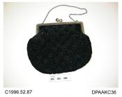 Bag, black velvet quilted and corded in four petalled mesh pattern, embossed white metal frame with twist knob closure, black and silver ball shaped knobs, fine chain handle, lined crepe de chine printed with brightly coloured flowers on a black ground,