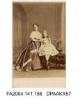 Photograph, Mrs Nottage standing with her daughter, Miss Nottage, seated at the end of a velvet couch, very grandly dressed, taken by The London Stereoscopic and Photographic Company, circa 1867-1870vol 1, page 20 - Our kind friends - assistants - and 