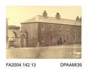 Photograph, the main entrance and the Officers Quarters at Cahir Barracks with men grouped around the doorway, taken by R Vervega, 1869vol 2, page 19