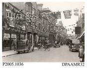 Photograph, black and white, showing decorated shops, in honour of King George V Silver Jubilee, London Street, Basingstoke, Hampshire. 1935