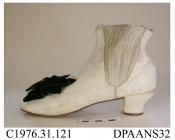 Boots, pair, women's, ankle boots, white kid, elasticated sides, cotton tabs attached at centre front and back for boot hooks, lined white cotton, squared toe with rounded corners, knock-on heel, toe trimmed large black velvet bow with plain oval steel 