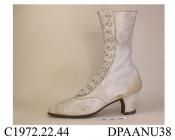 Boots, pair, women's, white kid, pointed toe with diamond point toecap and punched detail, twelve mother-of-pearl buttons to curved apron on outside of ankle, side seams curving over instep, straight rear seam covered with tapered kid trim, fairly strai