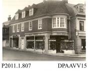 Photograph, black and white, showing the shop front of John Farmer Limited, shoe mfr, corner of Market Street and High Street, Alton, Hampshire