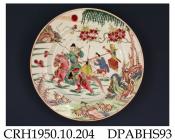 Plate, hard paste porcelain, decorated in famille rose colours with a warrior on horseback and attendant carrying a sword, box and writing scroll, they are crossing marshy ground; not marked, made in Jingdezhen, Jiangxi Province, with decoration possibl