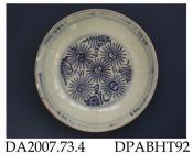 Saucer dish, hard paste porcelain, thickly potted, with crazed glaze, decorated with underglaze blue painted stylised flowers in well, accretions to footring; not marked, possibly Chinese provincial or other east-Asian country, c1700-1800
