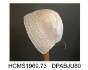 Baby's cap, fine linen, 2 sets of 3 drawstrings round face with ayrshire work snowflake motifs between, caul with diagonal lines of sprigs and eyelet flowers, matching 6.5 diameter crown with wreath and flowers, vandyked tabs, drawstrings over 6cm, embr