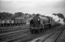 Digital image copy at 800 dpi of an original black and white print photograph retained by donor of Mike Peart, showing a King Arthur class locomotive 30765 "SIR GARETH" working a short parcels train approaching Winchester City Station from London.