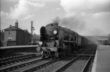 Digital image copy at 800 dpi of an original black and white print photograph retained by donor of Mike Peart, showing a rebuilt West Country class locomotive 34004 "YEOVIL" with a Bournemouth train travelling through Eastleigh Station.
