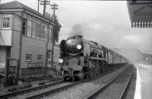 Digital image copy at 800 dpi of an original black and white print photograph retained by donor of Mike Peart, showing a rebuilt West Country class locomotive 34001 "EXETER" travelling through Micheldever Station with a Bournemouth train. 