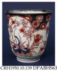 Beaker, hard paste porcelain, inverted bell shape, decorated in Chinese Imari style with a shaped underglaze blue border and painted red enamel tree, flowers and rocks; not marked, made in Jingdezhen, Jiangxi Province, China, about 1705-1720