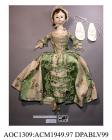 Doll, fashion doll or Pandora, made of wood, with jointed limbs, painted face and body and glass eyes, with real hair,1750-1770the doll is wearing a sack back dress of green and cream striped silk brocade over a stomacher. There is a full set of underg