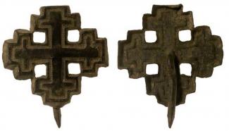 Copper alloy mount in the form of a cross crosslet with a single integral rivet, late medieval, circa 1485-1540. Found by metal detector at Badger Farm, Winchester, Hampshire. The outside edges of the mount are bevelled. The arrangement of the arms of t