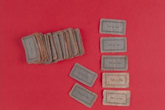 Toy money, 54 blue paper notes with sewn edges, printed as One Penny with floral border, possibly dating from the early 19th century.
