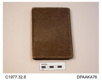 Wallet, brown sealskin, interior of brown calf, edges whipped narrow brown thonging, lined cream kid, two internal sections with clear plastic fronts edged narrow brown leather strip, divided section for stamps, separate sections for notes and documents
