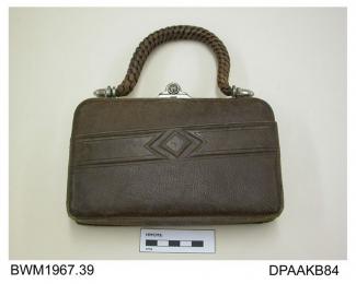 Handbag, brown leather on rectangular bright metal frame, slide closure, plaited leather handle, external front pocket with geometric design, lined cream leather with small internal pocket for vanity mirror, approximate depth 130mm, approximate width 18