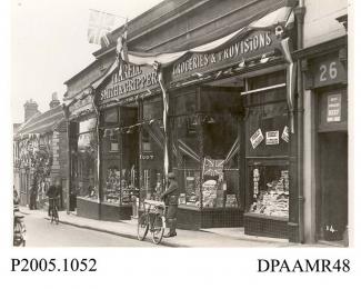 Photograph, black and white, showing decorated shops, in honour of King George V Silver Jubilee, Wote Street, Basingstoke, Hampshire. 1935