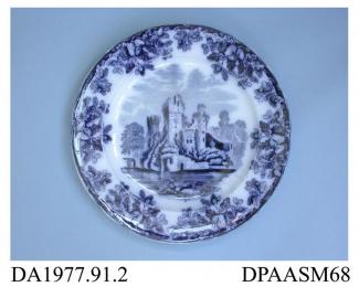 Dinner plate, or side plate, white earthenware, decorated with one of a group of flow blue printed designs showing a ruined lakeside castle within a border of oak leaves and acorns; back, impressed crown, printed factory mark in green and printed regist