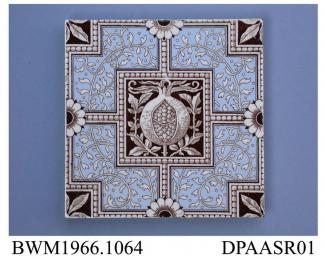 Tile, pressed clay dust, printed with scrolling foliage reserved in white on a blue ground and a pomegranate similarly shown in white on a solid sepia cartouche in centre; back, moulded ridges and factory marks and printed registered design mark with en