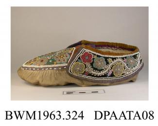 Slippers, pair, women's, moccasin style, chamois leather, lined coarse cream cotton, apron trimmed brown velvet edged purple ribbon binding, thickly beaded in stylized floral design of multi coloured beadwork, brown velvet of apron extends to form tongu
