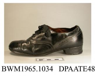 Shoes, pair, child's, black leather, front laced with four pairs of eyelets and wide black laces over full length tongue, galosh with toecap and punched detail, lined brown kid, squared toe, insole printed The Hansit, stacked leather heel with repair, l
