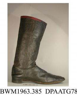 Boots, pair, men's, black leather, dress wellington boots, soft grained leather leg, top edge bound red leather and lined to match, webbing loops for boot hooks attached inside with decorative stitching, both boots have a torn hole in front of leg at mi