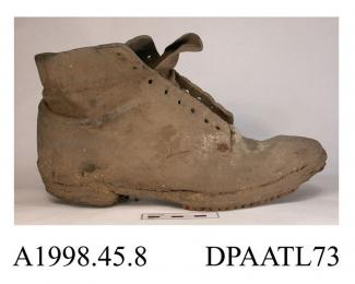 Boot, one only, men's, work boot, unlined, front laced eight pairs of eyelets over full length tongue, broad rounded toe, curved side seams, stacked leather heel crudely repaired with two pieces of leather, leather sole with rows of metal studs, very di