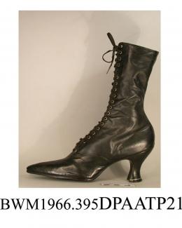 Boots, pair, women's, black leather, front laced with twenty pairs of eyelets and narrow black laces over full length tongue, needlepoint toe, curved side seams, straight rear seam, straight cut top, high curved and waisted Louis heel, metal plate betwe