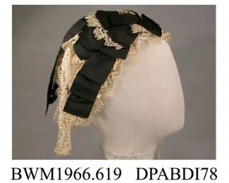 Cap, day cap, women's, Fanchon style,  Bedfordshire Maltese lace and black corded silk ribbon on a triangular base of black net, the cap is arranged as a graduated series of bows and lace frills from the brow over the crown, two long streamers of lace a