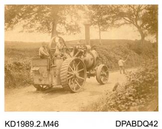 Photograph, sepia, showing a man with flag being followed by a front steering self propelled traction engine, named Hero, Salisbury, Wiltshire, built by Tasker and Co, Waterloo Foundry, Anna Valley, Abbotts Ann, Hampshire, 1860