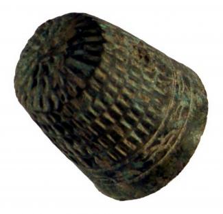 Copper alloy thimble, with a band of simple decoration around the base- rectangular indentations. Machine made, possibly imported and 17th century. From context 6001, Evans Halshaw site, Hyde Street, Winchester (WINCM:AY 35).