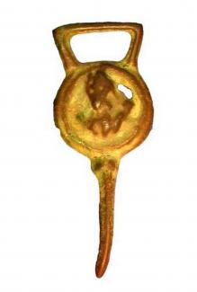 Post-medieval cast copper-alloy dress hook found by metal detector at Ovington, Itchen Stoke and Ovington, Hampshire. Circular, convex body, with raised circular border around a moulded possible wolf design. To right of this design perforated, possibly 