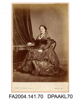 Photograph, Mrs Catherine Greenwood seated by a table with a book, taken by Mr Jabez Hughes of Ryde, Isle of Wightvol 1, page 11