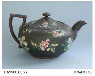 Teapot, black basalt stoneware, low round shape with angular handle, button knop on lid and scallop moulding at base of spout, decorated with famille rose enamelled flower sprigs and iron-brown details, impressed factory mark on base, made by Wedgwood, 