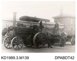 Photograph, black and white, showing three men with a steam engine and box trailer, built by Tasker and Co, Waterloo Foundry, Anna Valley, Abbotts Ann, Hampshire