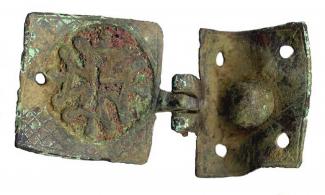 Copper alloy harness pendant decorated with a hatched square containing a sunk circular field orginally filled with red enamel and a cross pattern in relief. Also swivel with cross motif.